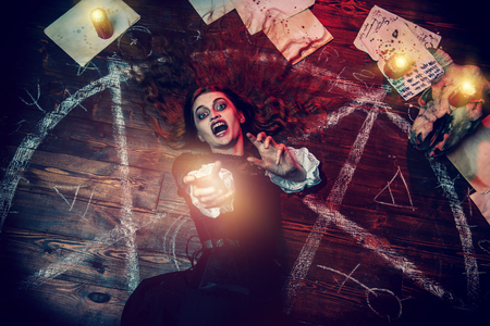 A portrait of a scary witch in the wooden house. Magic, dark force, spell.の写真素材