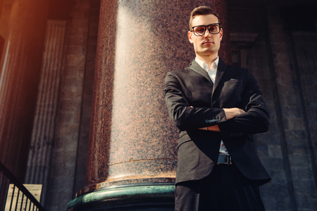A portrait of a goodlooking young student walking in the street. Men's beauty, fashion.の写真素材