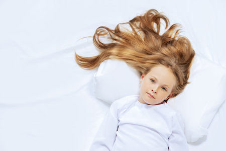 A portrait of a young pretty girl in bed. Relax, pajamas.の写真素材