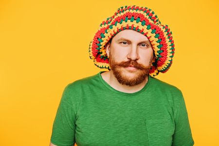 A portrait of a bright man posing in the studio over the yellow background. Men, beauty, colors, fashion, style.の写真素材