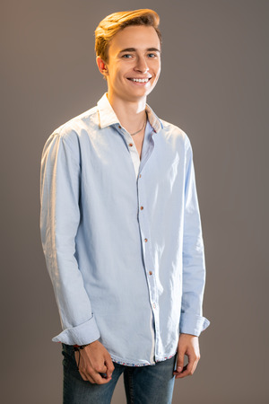 A portrait of a young goodlooking laughing guy in a white t-shirt. Beauty of men, casual fashion.の写真素材