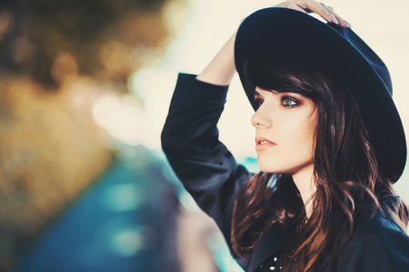 A portrait of a young fashionable woman wearing a hat walking in the street. Beauty, fashion.の写真素材