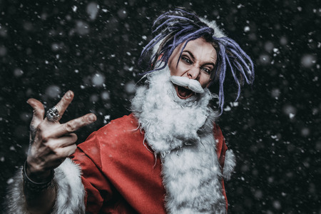 Portrait of a cool punk Santa Claus with bright dreadlocks over black background.の写真素材
