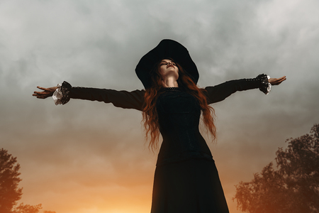 A portrait of an angry witch near the forest. Magic, dark force, spell.の写真素材
