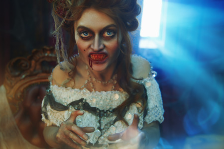 Vampires. Bloodthirsty female vampire in the old abandoned castle. Vintage style. Halloween.の写真素材