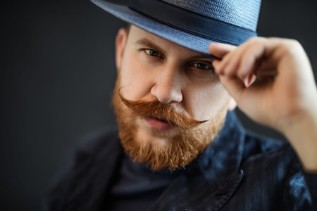 A close up portrait of a thoughtful man posing in the studio over the black background. Men's...