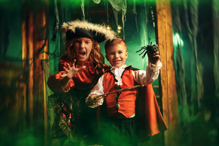 Happy children in carnival costumes celebrate halloween in the old castle. Halloween.の写真素材
