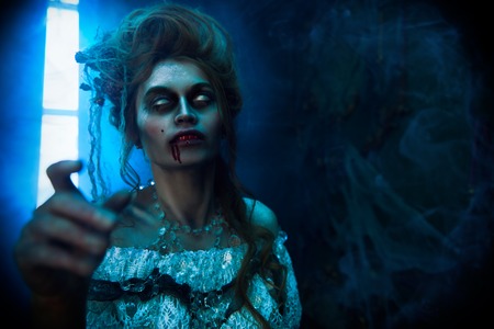 Vampires. Bloodthirsty female vampire in the old abandoned castle. Vintage style. Halloween.の写真素材