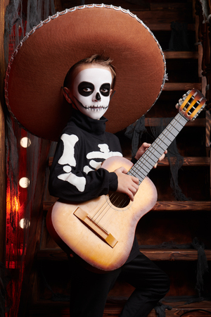 Sugar skull child boy in an old wooden house. Dia de los muertos. Day of The Dead. Halloween.の写真素材