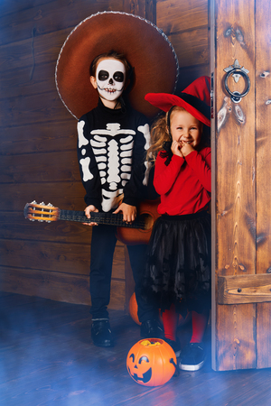 Happy children in witch and skeleton costumes celebrate halloween. Trick or treat. Halloween. Dia de los muertos. Day of The Dead.の写真素材