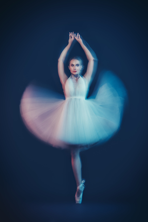 A full length portrait of a refined female ballet dancer posing in the studio over the black background. Talent, fashion for ballet dancers.の写真素材