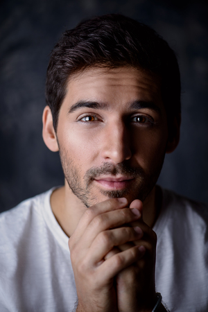 Close-up portrait of a handsome young man wearing white t-shirt. Studio shot. Men's beauty and health.の写真素材