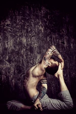 An experienced yoga instructor showing different yoga poses over dark background. Healthy lifestyle. Meditation, concentration.の写真素材