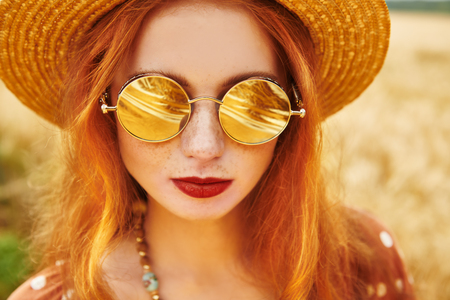 Portrait of a modern hippie girl in a wheat field. Bohemian style.の写真素材