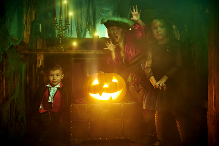 Children in carnival costumes look for treasures in the old castle. Halloween.の写真素材