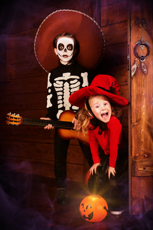 Happy children in witch and skeleton costumes celebrate halloween. Trick or treat. Halloween. Dia de los muertos. Day of The Dead.の写真素材