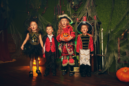Happy children in carnival costumes trick or treating on Halloween.の写真素材