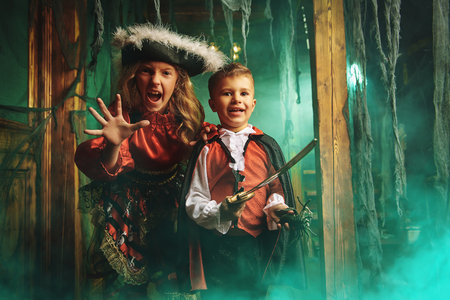 Happy children in carnival costumes celebrate halloween in the old castle. Halloween.の写真素材