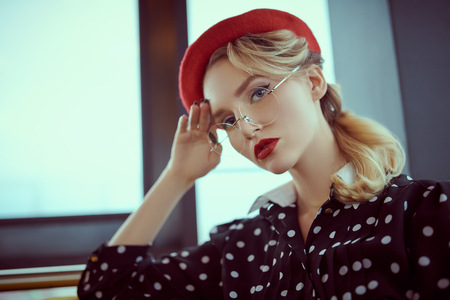 Portrait of an elegant young woman with make-up and clothes in pin-up style. Beauty, fashion. Optics and eyewear.の写真素材