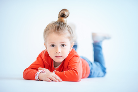 A portrait of a pretty child girl posing in the studio over the white background. Kids, fashion, casual style, beauty.の写真素材