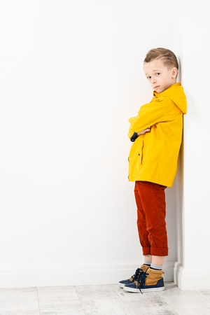 A full length portrait of a handsome child boy posing in the studio over the white background. Kids, fashion, casual style.の写真素材
