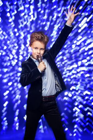 A portrait of a cheerful cute boy with microphone.の写真素材