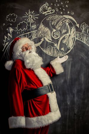 A portrait of Santa Claus standing in a classroom near the blackboard.の写真素材