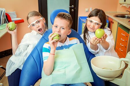 A portrait of three happy children in the cabinet of a dentist. treatment, medicine, hospital.の写真素材