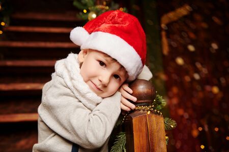 Christmas is a happy family holiday! Cute children celebrate Christmas and give gifts in a beautiful festive home atmosphere. Christmas and New Year concept.の写真素材