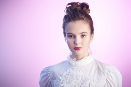Portrait of a beautiful young girl with natural make-up and fresh skin in a light pink haze. Spring and youth. Beauty and cosmetics concept. Copy space.の写真素材