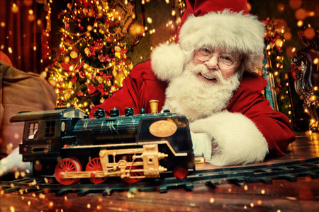 Good old Santa Claus brought gifts for Christmas and sat down to play a steam train in a beautiful...