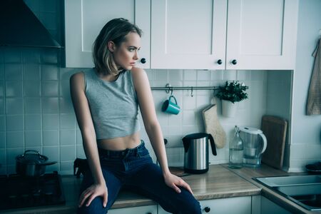 A portrait of a beautiful girl posing in the kitchen. Fashion, interior.の写真素材
