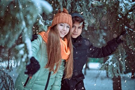 Two happy young people walking in a beautiful winter park. Winter holidays.の写真素材