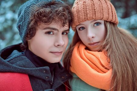 Portrait of two happy young people walking in a beautiful winter park. Winter holidays.の写真素材