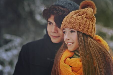 Portrait of two happy young people walking in a beautiful winter park. Winter holidays.の写真素材