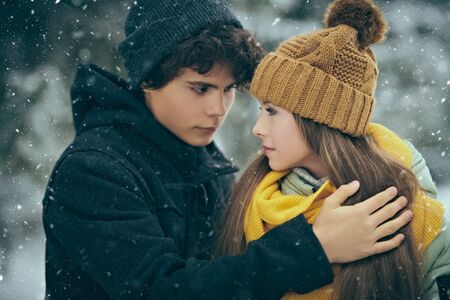 Couple of happy romantic young people hugging in a winter park and smiling. Winter season.の写真素材