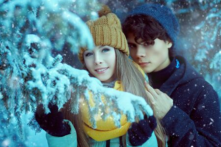 Portrait of two happy young people walking in a beautiful winter park. Winter holidays.の写真素材