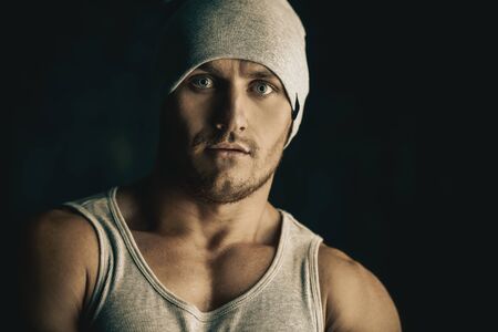 Close-up portrait of a masculine athletic man over black background. Sports and bodybuilding concept.の写真素材