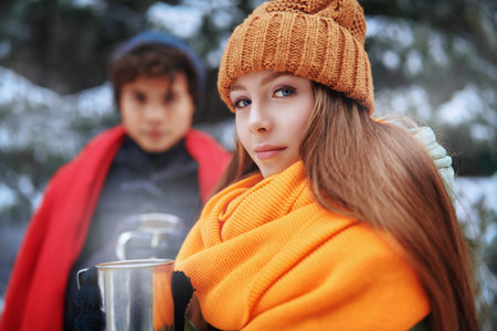A young girl and her boyfriend spend time together happily in the winter forest. Winter season,...