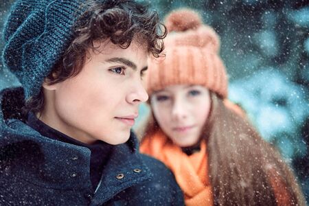 A young man and his girlfriend walk happily in the winter forest. Winter season, winter activities.の写真素材