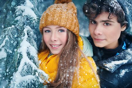 Portrait of two happy young people walking in a beautiful winter park. Winter holidays.の写真素材