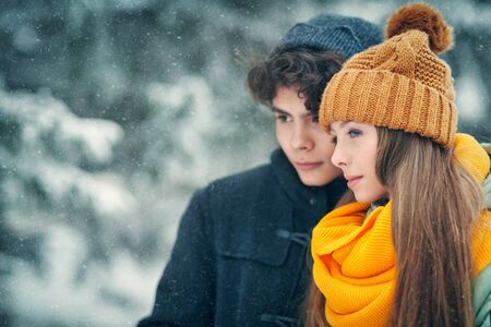 Portrait of two happy young people walking in a beautiful winter park. Winter holidays.の写真素材