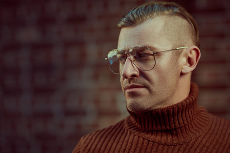 Handsome mature man in glasses over brick wall background. Optics style. 