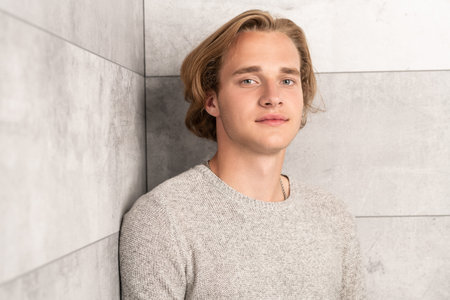 A portrait of a young attractive man posing indoor. Casual men fashion, beauty.