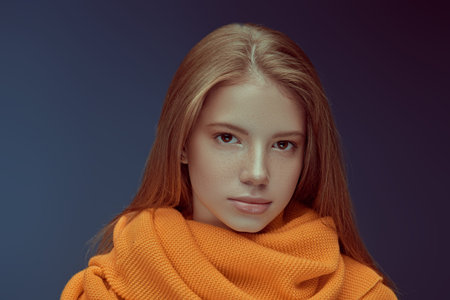 Portrait of a pretty modern girl teenager looking at camera. Studio portrait on a dark blue...