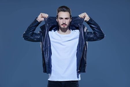 Men's fashion. Handsome man in casual white t-shirt and black leather jacket. Studio portrait.の写真素材