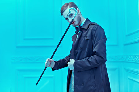 Art and fashion. A young man with makeup in the style of the 20s poses in an elegant suit in a...