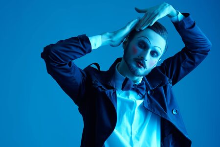 Art and fashion. Portrait of a young man with makeup in the style of the 20s in an elegant suit playing different life roles. Male mime artist.の写真素材