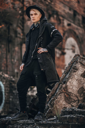 A full length portrait of a young fair-haired guy walking in the street. Casual fashion, beauty.