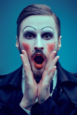 Art and fashion. Portrait of a young man with makeup in the style of the 20s in an elegant suit playing different life roles. Male mime artist.の写真素材